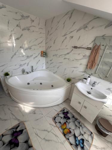 a bathroom with a white tub and a sink at Casa Happy in Petroşani