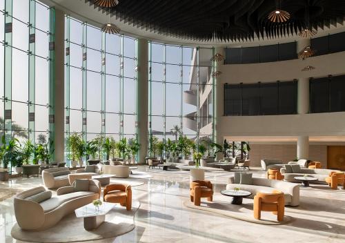 a lobby with couches and tables in a building at Ray Hotel by Cloud 7 in Kuwait