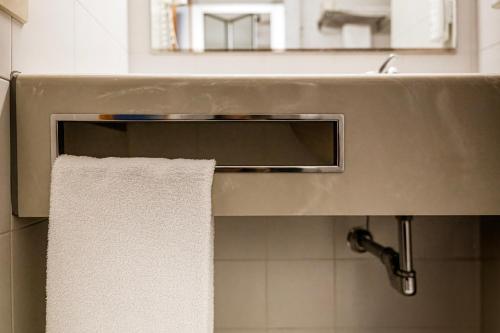 a towel hanging from a sink in a bathroom at Hotel Cavallino in Faenza