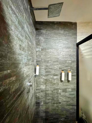 a bathroom with a shower with a stone wall at Casa Terraza Oaxaca in San Sebastián Etla
