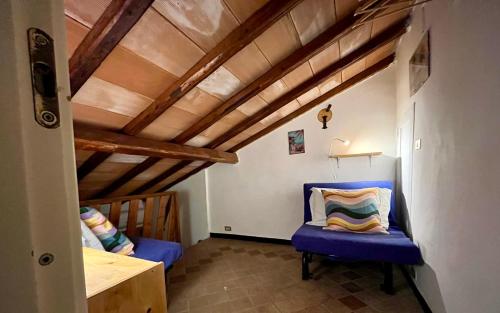 a room with a blue chair and a wooden ceiling at Il noce - case vacanza- in Sestri Levante