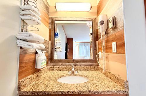 a bathroom with a sink and a mirror at Travelodge by Wyndham Golden Sportsman Lodge in Golden