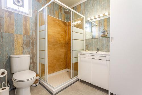 a bathroom with a shower and a toilet and a sink at Casa das Flores by Hostiva in Aroeira
