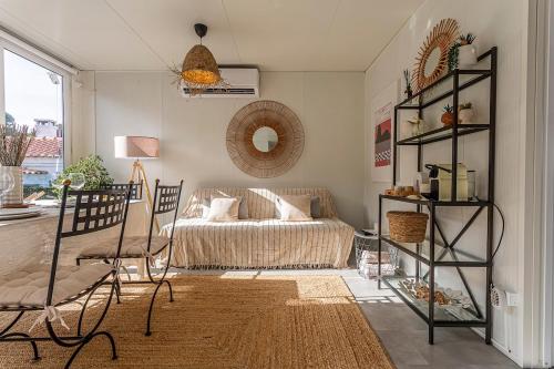 a living room with a bed and chairs in it at Casa das Flores by Hostiva in Aroeira