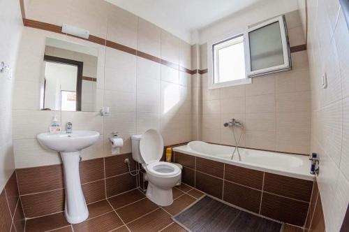 a bathroom with a sink and a toilet and a bath tub at Paliouri Villas in Paliouri