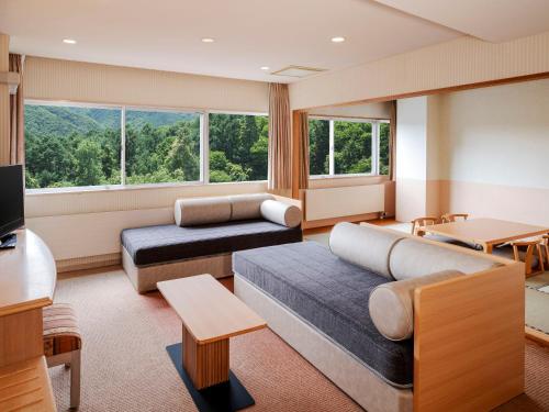 a living room with two couches and a large window at AZUMINO KOGEN Resort in Azumino