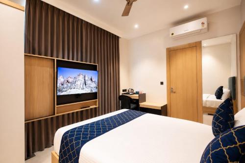 a hotel room with a bed and a flat screen tv at Hotel Shri Govindam Banaras with Parking in Varanasi