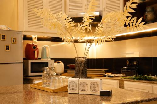a vase with flowers on a counter in a kitchen at Thềm Homestay in Da Thien