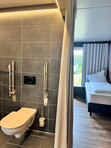 a bathroom with a bed and a toilet in a room at CBS Hotel by WMM Hotels in Cottbus