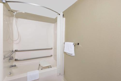 a bathroom with a shower with a mirror and a tub at Super 8 by Wyndham Macomb in Macomb