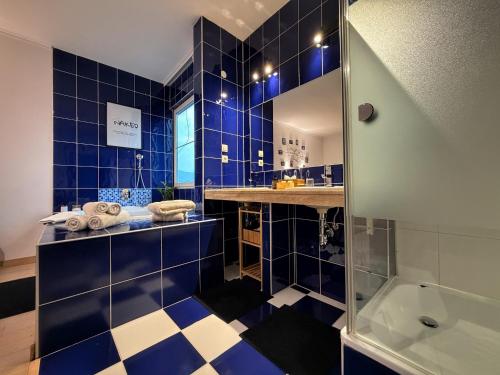 a blue tiled bathroom with a shower and a tub at L69 Apartments - Angel's Apartment in Banská Bystrica
