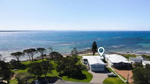 an aerial view of a house and the ocean at Ocean Blue Apartment One in Currarong