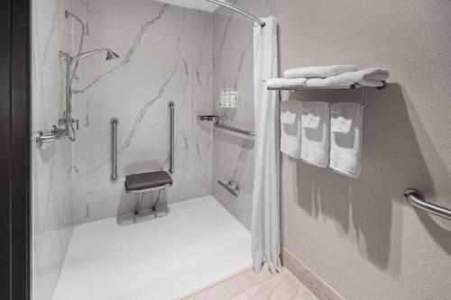 a white bathroom with a shower with towels at Baymont by Wyndham Salida in Salida