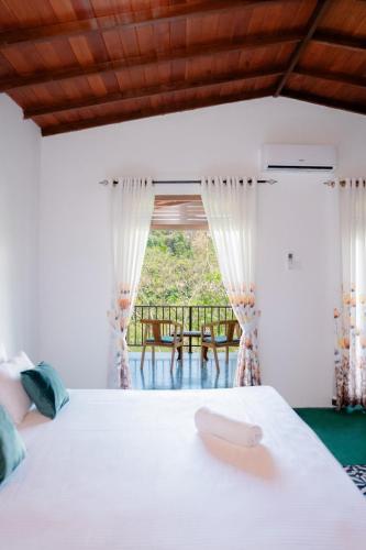 a bedroom with a bed and a view of a table at Circle Edge Resort in Kandy