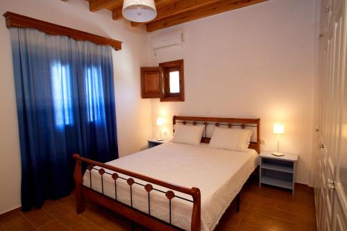 a bedroom with a bed and a blue curtain at Thea House Patmos in Kámbos