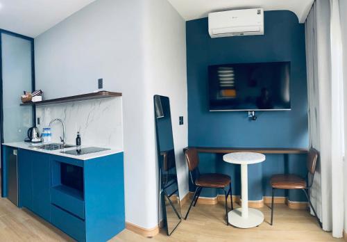 a kitchen with blue walls and a table and chairs at Lapit Hotel And Apartment in Da Lat