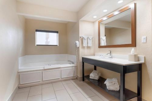 a bathroom with a tub and a sink and a mirror at Comfort Inn Ebensburg in Ebensburg
