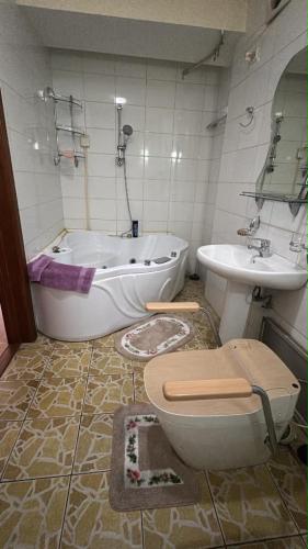 a bathroom with a tub and a toilet and a sink at Near ASA Arena Circus in Ulaanbaatar