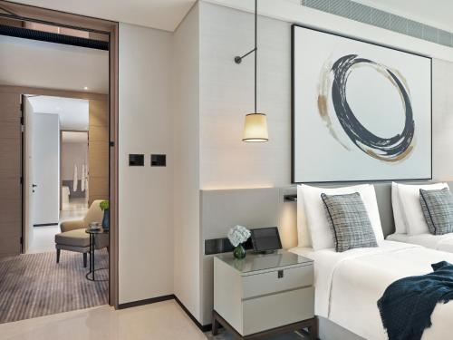 a bedroom with a white bed and a pendant light at Address Beach Resort in Dubai