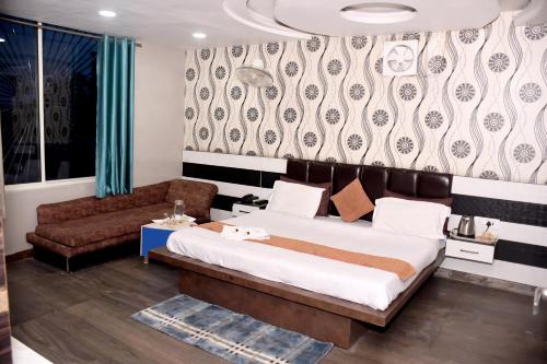a bedroom with a large bed and a couch at Hotel J P Residency in Datia