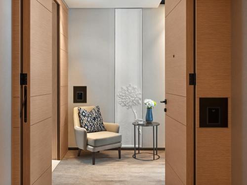 a room with a chair and a table with a vase of flowers at Address Beach Resort in Dubai