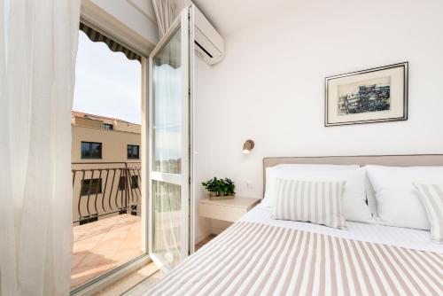 a bedroom with a bed and a balcony at BANKO APARTMENTS & Rooms in Rovinj