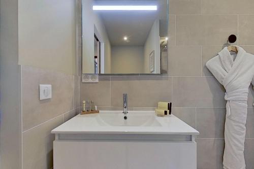 a bathroom with a white sink and a mirror at La Lézardière - Suites de Prestige & Spas Privatifs in Porto-Vecchio
