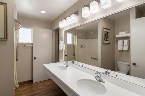 a bathroom with two sinks and a large mirror at Ramada Bayside Inn & Suites Eureka in Eureka