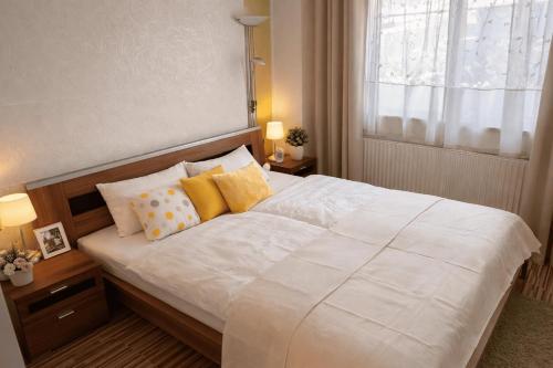 a bedroom with a large white bed with yellow pillows at Ferienwohnungen Gutenbrunn in Gutenbrunn