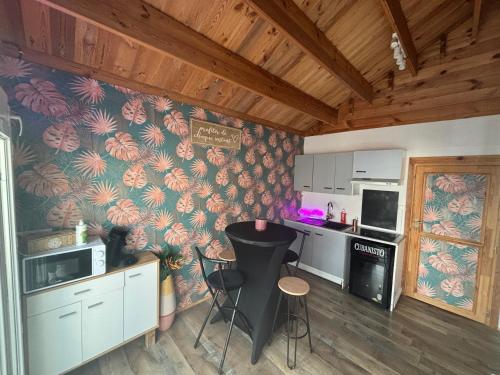 a kitchen with floral wallpaper and a table and chairs at Flyby pole studio in Béziers