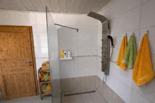 a bathroom with a shower with yellow towels and a door at Ferienwohnungen Gutenbrunn in Gutenbrunn
