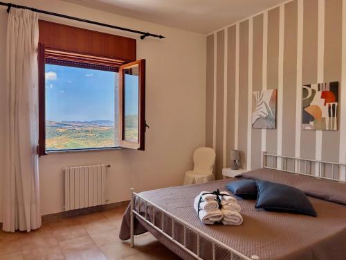 a bedroom with a large bed and a window at Casa Verdi in Corleone
