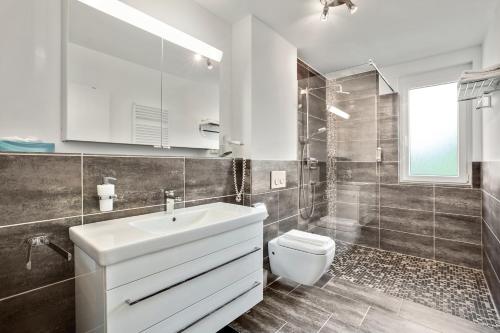 a bathroom with a white sink and a toilet at Ferienwohnung Landblick im Markgräflerland mit kostenlosem Parkplatz in Bad Bellingen