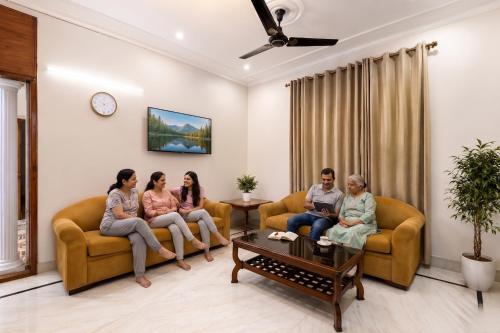 a group of people sitting in a living room at FabHotel The Arjun Sushant lok - Iffco Chowk Sector 29 in Gurgaon