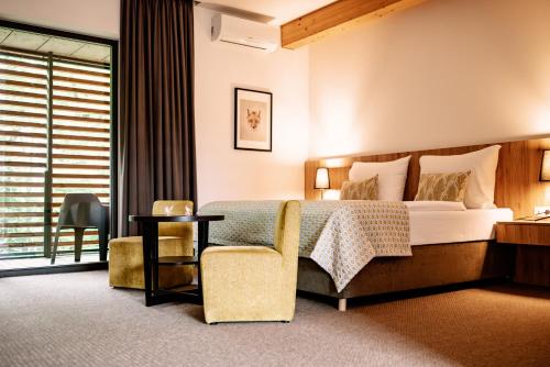 a hotel room with a bed and a chair at Hotel Château Gbeľany in Žilina