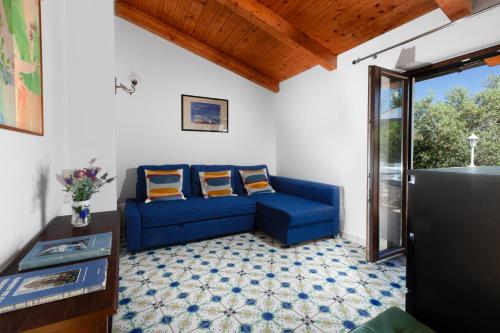 a blue couch in a living room with a window at Gaiano Apt in Sorrento