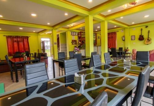 ein Esszimmer mit einem großen Glastisch und Stühlen in der Unterkunft Hotel Nigale in Dhankuta
