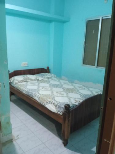 a bedroom with a bed in a blue room at Om Sai Manjunatha Residency in Puttaparthi