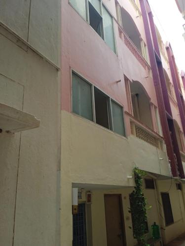 a pink building with a door in front of it at Om Sai Manjunatha Residency in Puttaparthi