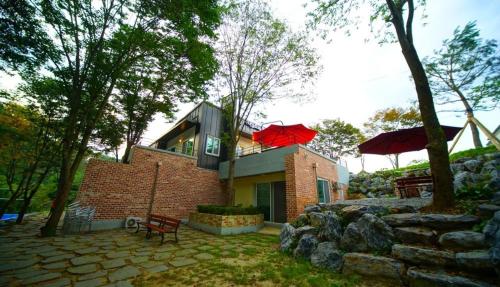 a house with a red umbrella on top of it at Namusori pension in Koesan