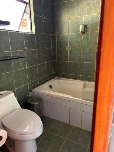 a bathroom with a toilet and a bath tub at Habitación Suite in Chimbarongo