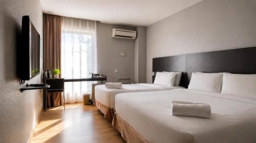 a hotel room with two beds and a window at The Leverage Business Hotel - Rawang in Rawang