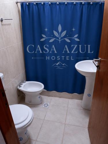 a bathroom with two toilets and a blue shower curtain at Casa Azul in La Quiaca