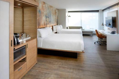 a hotel room with a white bed and a desk at Cambria Hotel Phoenix Chandler - Fashion Center in Chandler