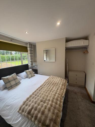 a bedroom with a large bed and a window at Gatwick 'Bit on the Side' in Copthorne