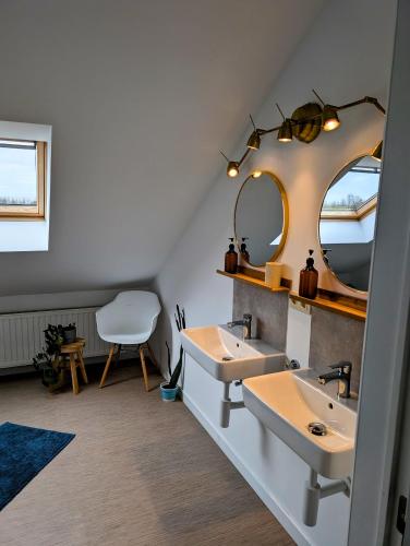 a bathroom with two sinks and a mirror at De Oude Katsei in Gingelom