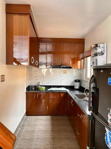 a kitchen with wooden cabinets and a counter top at Aranya Villa in Bākhri Kharka