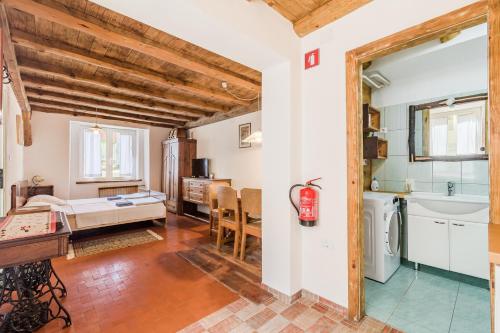 a bedroom with a bed and a bathroom with a sink at Farmhouse Cvetje in Tolmin