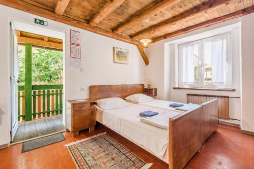 a bedroom with a bed and a large window at Farmhouse Cvetje in Tolmin