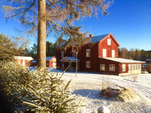 a large red barn with snow on the ground at THE LODGE Torsby in Torsby